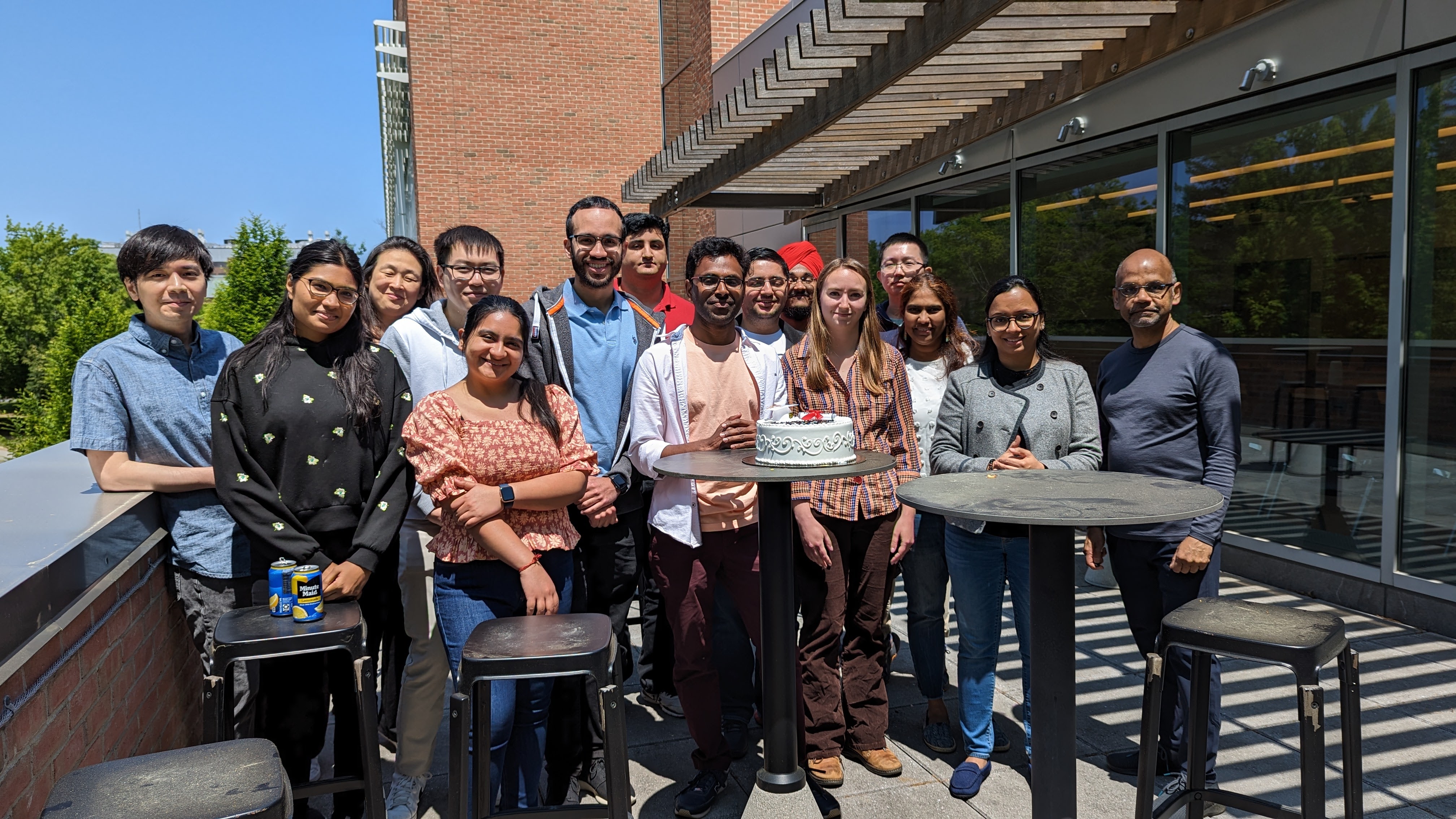 Mallesh Dasari and lab mates in front of a cake. 
